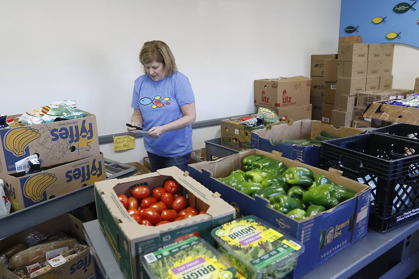 Volunteer Kathy Lambert checks her list as she picks food for a recipient Tuesday, Jan. 10, 2023, inside the FISH of McHenry Food Pantry, 3515 N. Richmond Road in Johnsburg. The pantry, which has changed how it distributes food since the COVID-19 pandemic, is now raising $150,000 to add more storage and a heated garage onto the building.