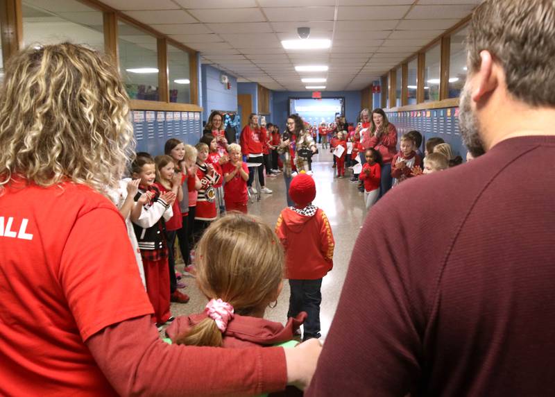 Marshall Morong, (center) 7, a first grader at Hinckley-Big Rock Elementary School, and his family are cheered on as they walk to his classroom Monday, May 5, 2025, after arriving for his first day back at school following months waiting for, and eventually receiving, heart transplant surgery at Lurie Children’s Hospital of Chicago. Morong arrived in style in a Tesla Cybertruck donated for use by Telsa of Naperville, along with an escort by Hinckley and Big Rock first responders.