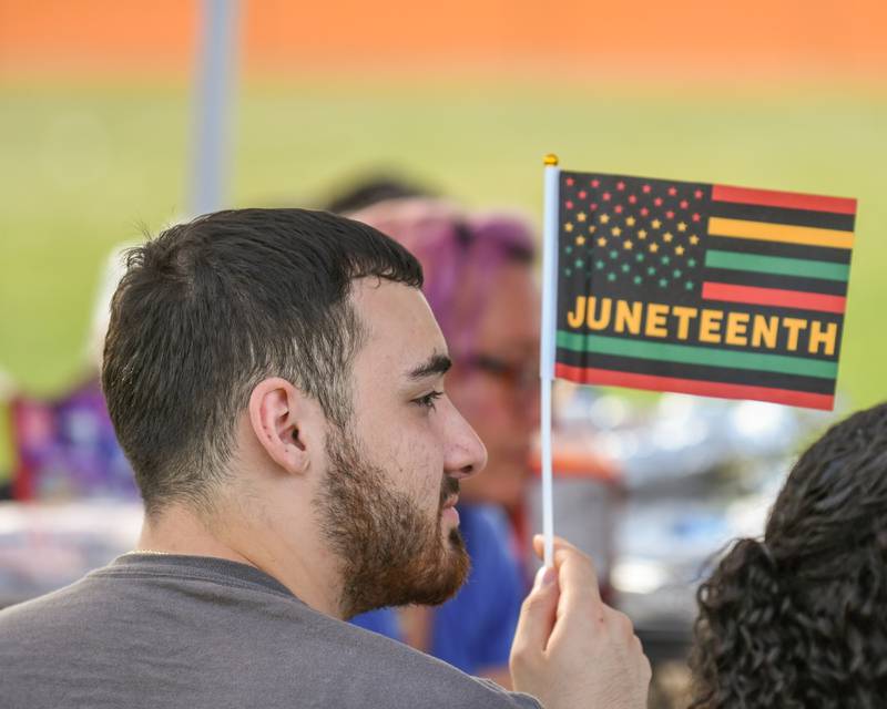 Cristian Rodriguez of South Elgin waves a Juneteenth flag during the Juneteenth celebration on Saturday June 15, 2024, held at Emily G. Johns School in Plano.