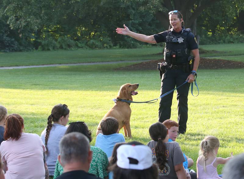 Princeton Police K-9 handler Sara Larkin, talks to kids about her partner Lucy, a certified Bloodhound trained in man trailing during the National Night Out event on Tuesday, Aug. 5, 2025 at Zearing Park in Princeton. The event featured K-9 and drone demonstrations, Mr. Cinnamon balloon twister, face painting, emergency vehicles, and more. National Night Out is an annual community policing campaign held on the first Tuesday of August to create police-community partnerships and build safer neighborhoods.