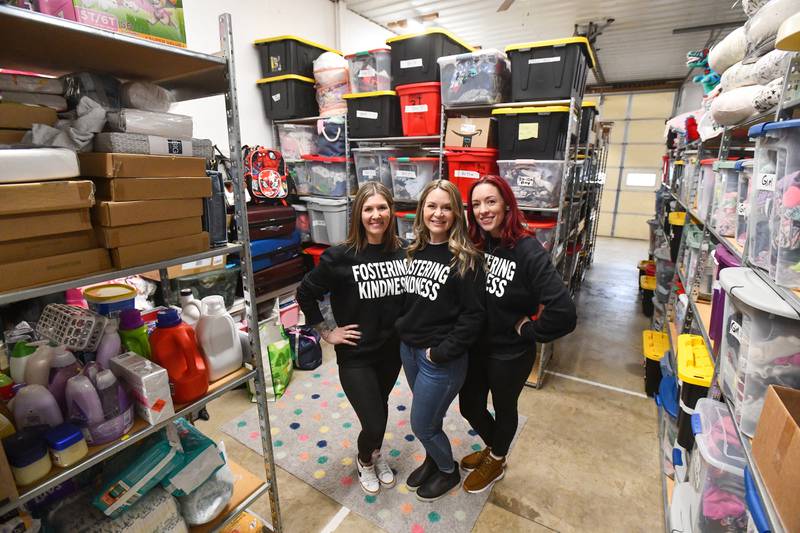 Foster moms Rachel Langlois, right, of Kankakee, Mallory Handford, center, and Allie Brooks, both of Bourbonnais, stand in the area of Langlois' shed that houses hundreds of donations for Georgie's Closet, which provides children in foster care and their foster families in Kankakee County with clothing and essential items.