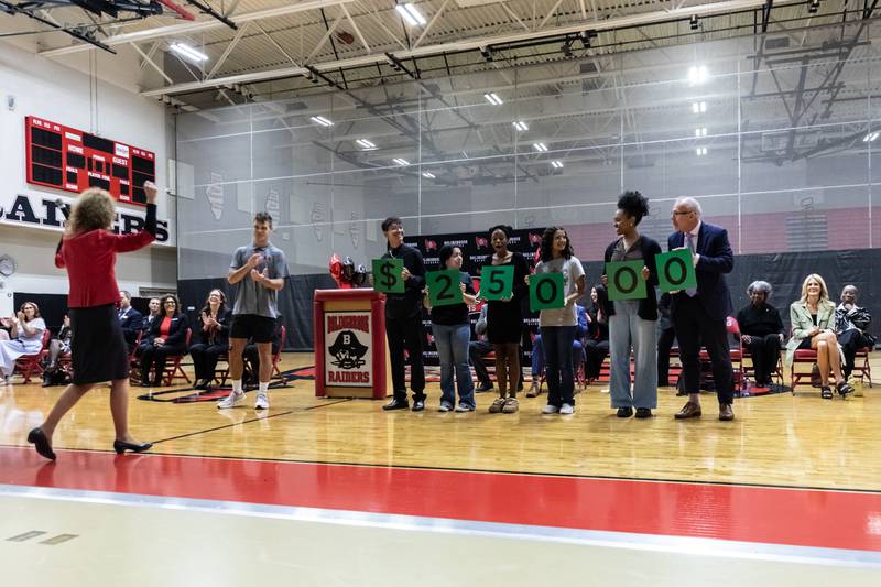 Students help Milken Educator Awards Senior Vice President Dr. Jane Foley and Illinois Superintendent of Education Dr. Tony Sanders announce the monetary prize at the surprise assembly during which Dr. Jaclyn Lennox, Bolingbrook High School’s assistant principal, was honored with the Milken Educator Award at Bolingbrook High School on Oct. 16, 2025.