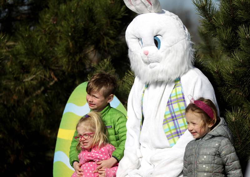 Siblings Beckham, 6, Farrah, 2, and Kennedy Greenlees, 4, pose for a photo with the Easter Bunny during an egg hunt hosted by the Glen Ellyn Park District at Maryknoll Park on Friday, April 7, 2023.