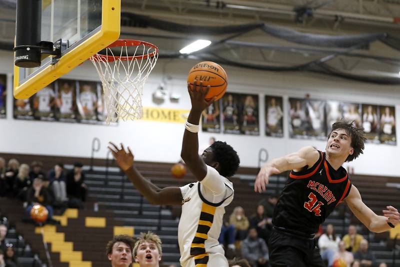 Jacobs' Samson Averehi gets under the block attempt of McHenry's Carter Sites during a Fox Valley Conference basketball game on Friday, Jan. 24, 2025, at Jacobs' High School.