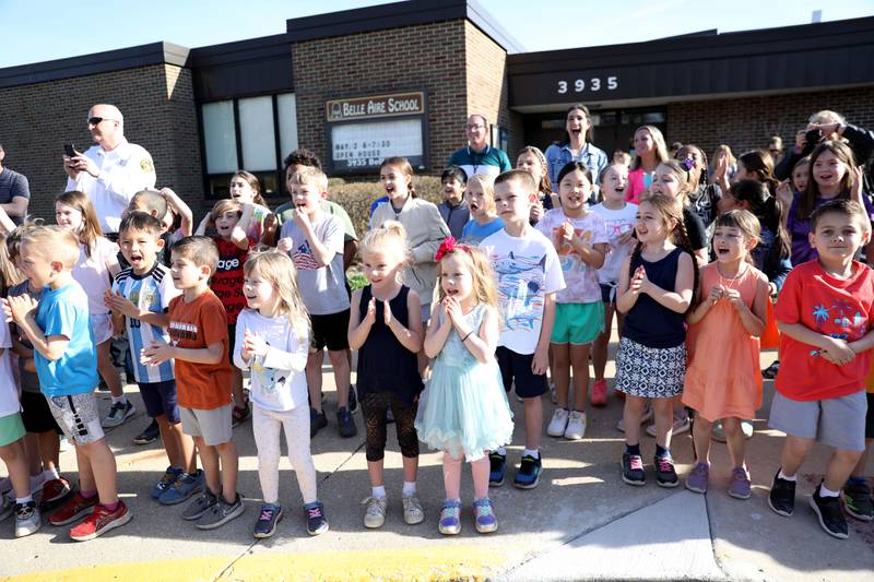 Students at Belle Aire Elementary School in Downers Grove yell as a fire truck, with sirens and lights, pulls up to the school carrying third-grader Kyla Richardson and her first-grade sister, Laina. Kyla won the trip by entering a contest sponsored by the  Fire Department as part of the Learn Not to Burn program.