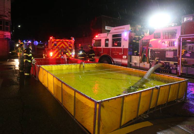 Firefighters fill tender boxes at Walnut and 5th Streets to fight a fire across from the Westclox building on Friday, July 14, 2023 in Peru. The fire began at 8:19p.m. A MABAS box alarm was issued to the fourth level and then brought back down after the fire was contained.