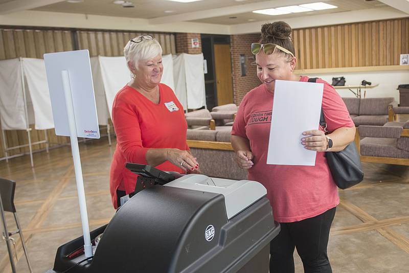 Election judge Susan Meany (left) shows voter Samantha Spera how to file her ballot in Dixon on Tuesday, June 28, 2022 for the state primary. Voting has once again moved from electronic ballots back to paper.