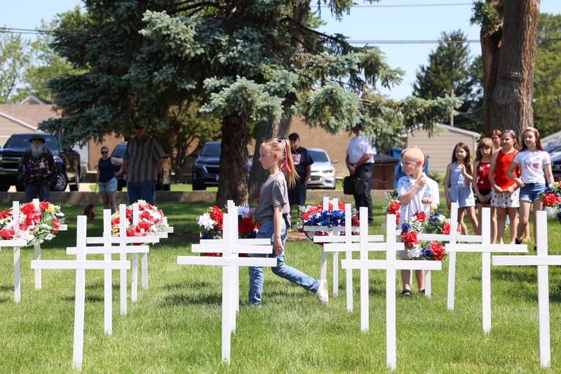 Dixie Norton, 8, of Clifton, carries a wreath to be placed on a cross honoring a fallen service member during the Bradley American Legion's Memorial Day ceremony on Monday, May 25, 2026.