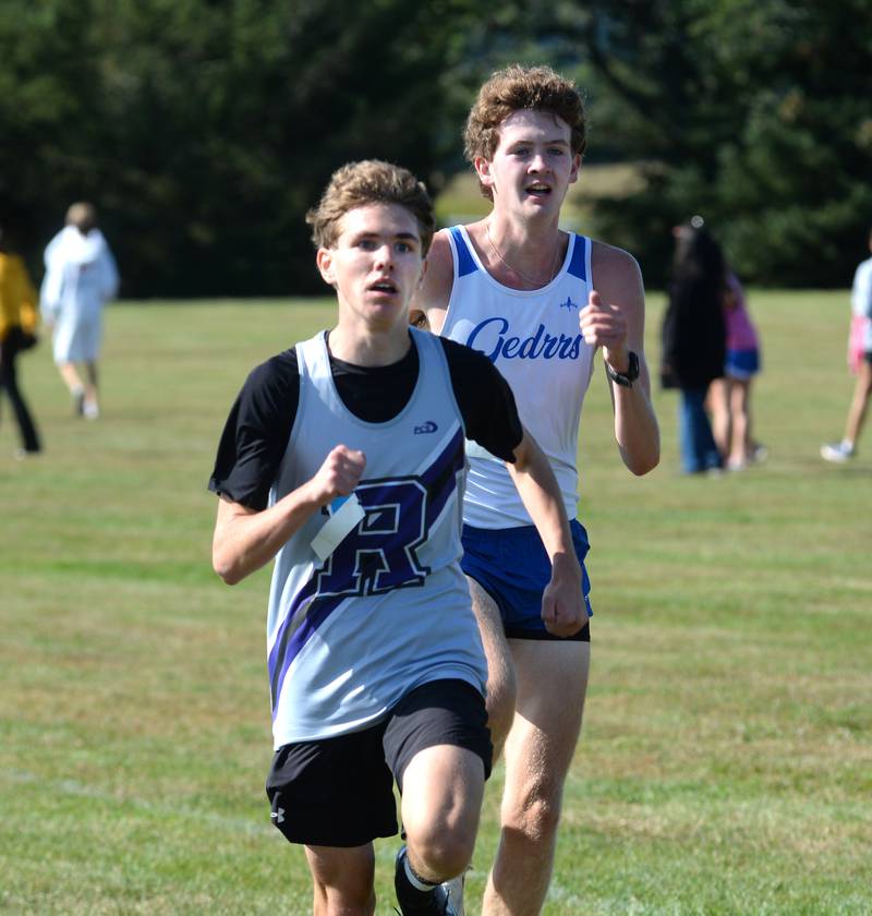 Rocehlle's Tyler Johnson races East Dubuque's Andrew Richardson to the  finish line, finishing 13th at the Oregon Cross Country Open on Saturday, Sept. 6, 2025 at Oregon Park West.