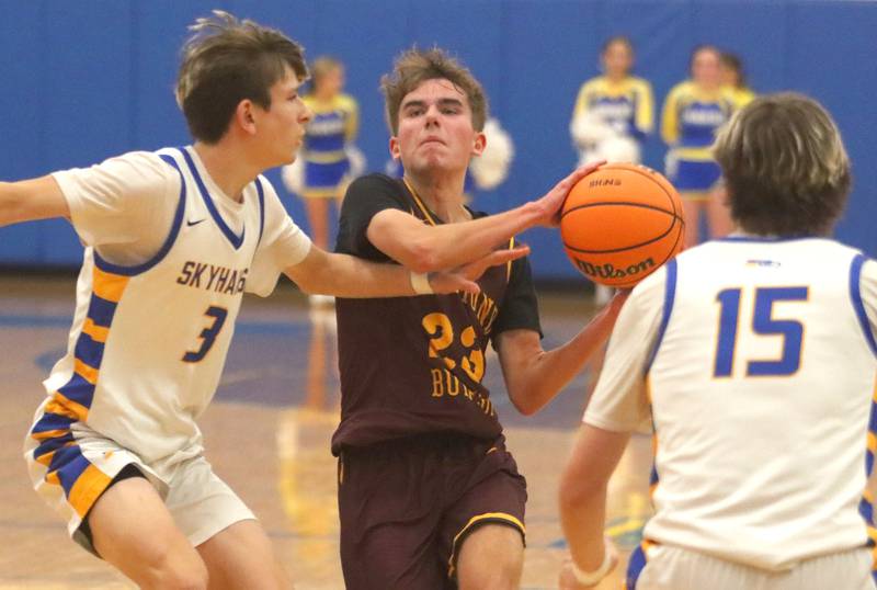 Richmond-Burton’s William Gardner, center, works under the hoop against Johnsburg’s Trey Toussaint, left, in varsity boys basketball onTuesday, Dec. 9, 2025, at Johnsburg High School in Johnsburg.