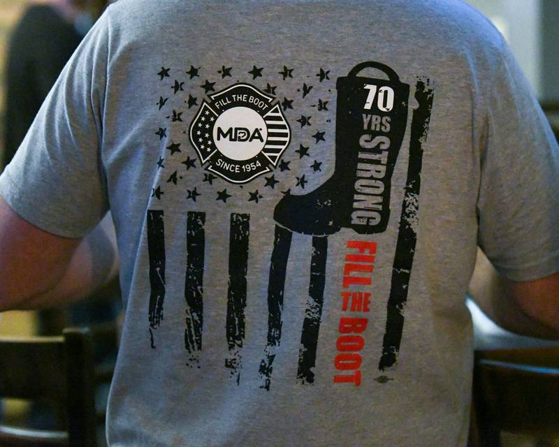 Members of the DeKalb fire department don special event shirts on Wednesday Nov. 27, 2024, at Fatty's Pub and Grille in DeKalb during the DeKalb Fire Fighters Local 1236 union's Tip A Firefighter event to fundraise for the Muscular Dystrophy Association.