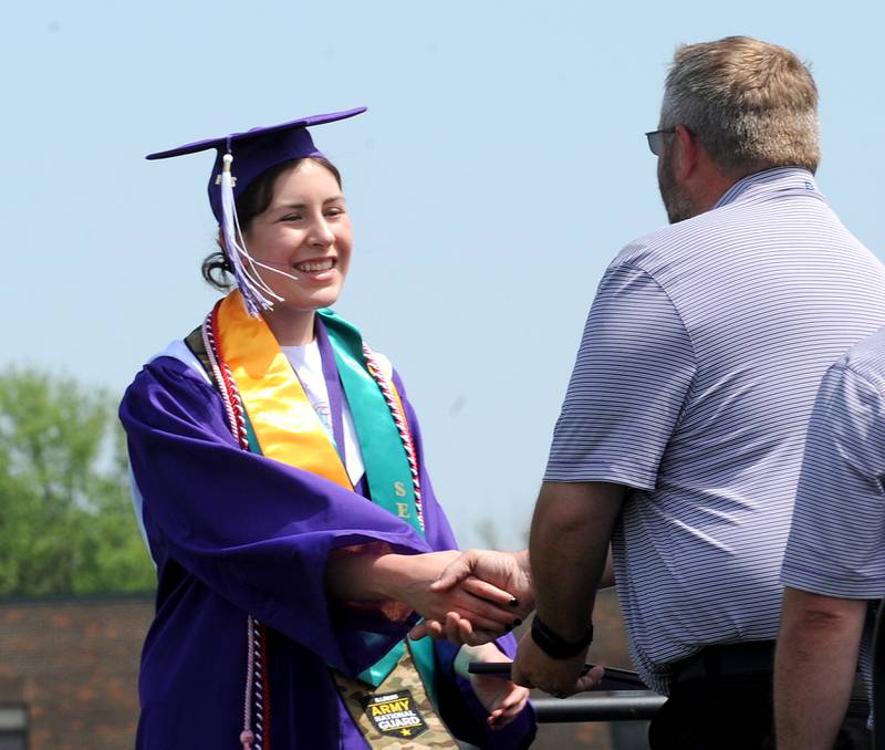 A Plano graduate receives her diploma during Plano High School's graduation ceremony on the football field, Sunday, May 19, 2024.