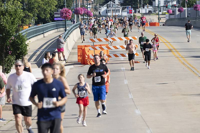 Runners are in the home stretch as they cross the Peoria Avenue bridge during the Reagan Run on Saturday, July 6, 2024. Starting at the Reagan Boyhood Home, the run takes participants through Page Park and finishes at Haymarket Square.