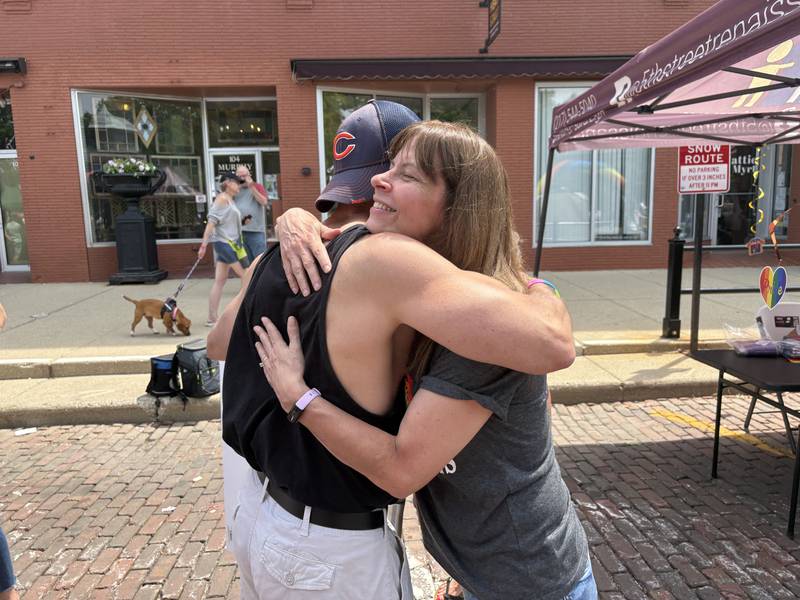 Mike DeCicco, left, hugs Laurie Milkent during Woodstock PrideFest June 15, 2025.
