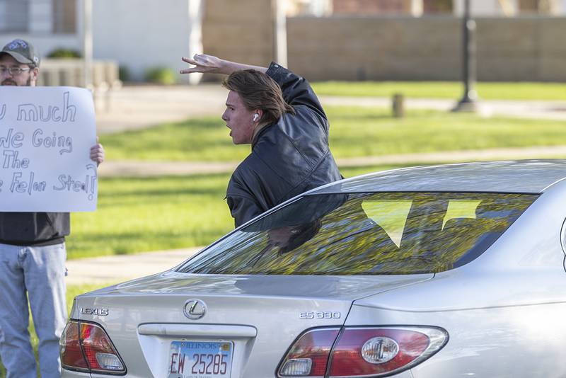 A supporter leans out of a car Friday, May 1, 2026, during a May Day protest at Central Park in Sterling. Indivisible Sauk Valley organized the gathering to continue to voice their displeasure with the Trump Administration.