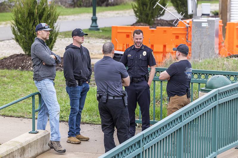 Dixon Police Chief Ryan Bivins (middle) speaks to police and fire personnel Tuesday, April 14, 2026, after an individual jumped over the railing off of the Peoria Avenue Bridge late Monday night.