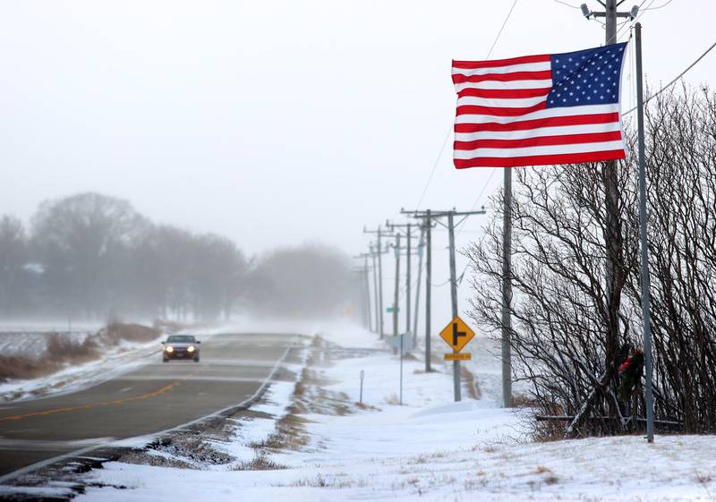 A flag at the Storm Cemetery near Marengo on Friday morning indicates a stiff wind following Thursday snowfall.