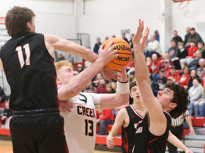 Indian Creek's Isaac Willis drives in the lane as Woodland's Nate Berry and Brezdyn Simons defend during the Class 1A Sectional Semifinal game on Wednesday, March 4, 2026 at Amboy High School.