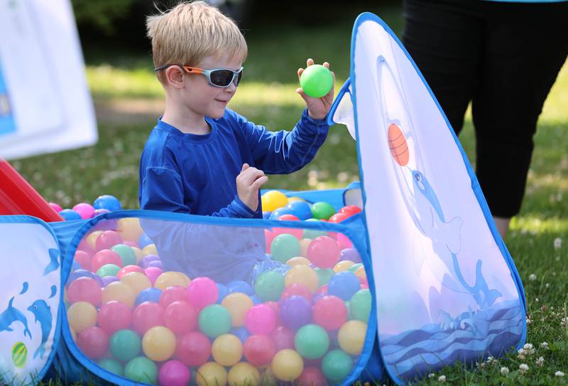 Xander McTurner, 6, from Naperville, plays in the ball pit at the Westside Children’s Therapy booth during the Family Fun Fest Thursday, July 20, 2023, at Hopkins Park in DeKalb.
