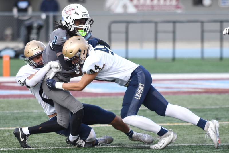 Kankakee's Cedric Terrell III, center, is tackled by Lemont's Jackson Dybcio, left, and Evan Rediehs during an IHSA Class 5A playoff game at Kankakee Saturday, Nov. 1, 2025.