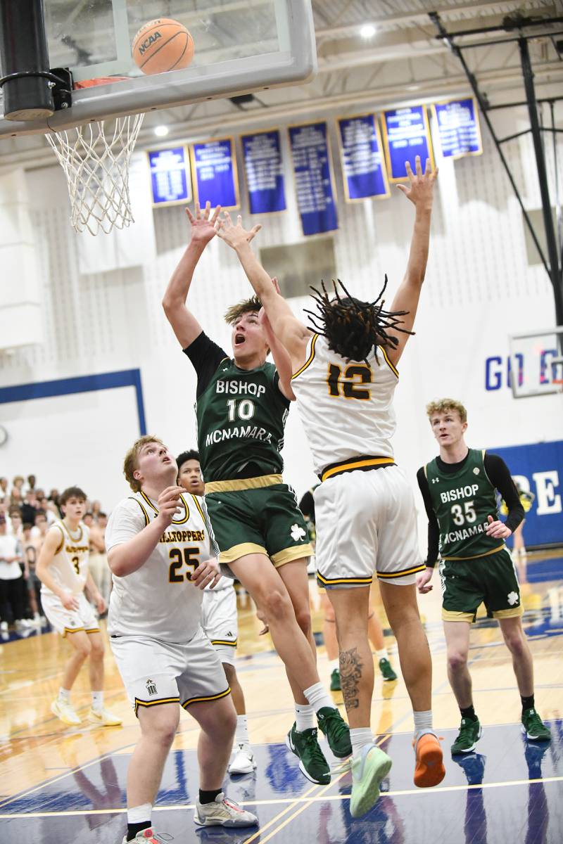 Bishop McNamara's Dylan Denoyer shoots under pressure from Joliet Catholic Academy's JJ Sterrett during the Fightin' Irish's 79-67 victory over the Hilltoppers in the IHSA Class 2A Peotone Sectional semifinal on March 4, 2025.