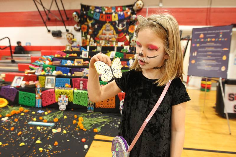 Olivia Schlangen, 7, of Spring Grove holds up a butterfly she made to honor her cat, Charlie, during the Dia de los Muertos, Day of the Dead event at Stanton Middle School on November 4th in Fox Lake. The event was sponsored by the Bilingual Parents Advisory Committee (BPAC) from School Districts 114,124 and 37. Olivia was at the event with her mother, Vanessa. Students were able to wear their Halloween costumes to the event.
Photo by Candace H. Johnson for Shaw Local News Network