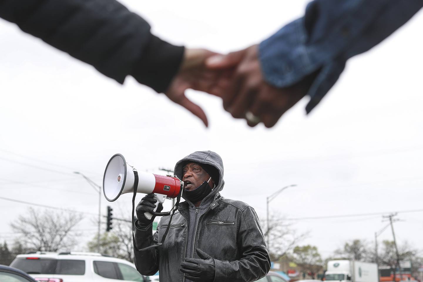 Rev. Larry Ellis of St Mark CME Church calls for justice for George Floyd as demonstrators hold hands in prayer on Monday, April 19, 2021, at the intersection of Jefferson St. and Larkin Ave. in Joliet, Ill. Members of Joliet's community of faith came together to raise awareness and call for justice for George Floyd.