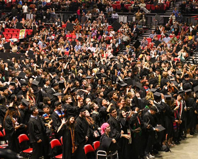 Caps fly into the air at the end of the DeKalb High School graduation ceremony on Saturday May 23, 2026, held at the Convocation Center in DeKalb.