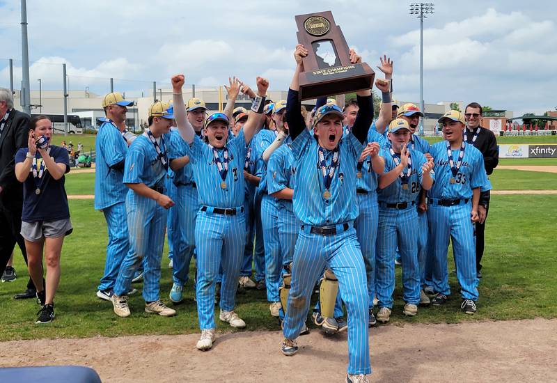 Marquette's Carson Zellers, winning pitcher in the Class 1A state championship game on Saturday, and his teammates show the Crusaders fans the title trophy.