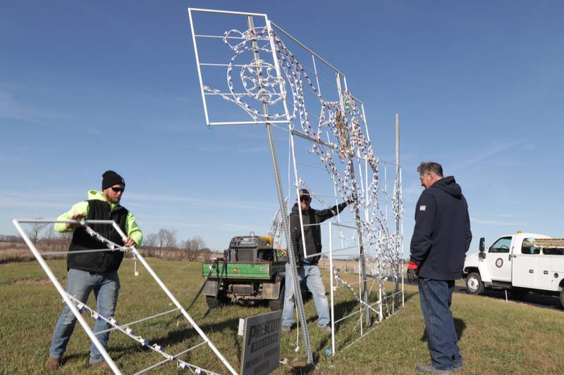 City of La Salle employees Derek Piecha, Biran Milus and Mike Girton hang Christmas light displays at Rotary Park on Monday, Nov. 7, 2022 in La Salle. The park will be open to the public beginning this Friday.