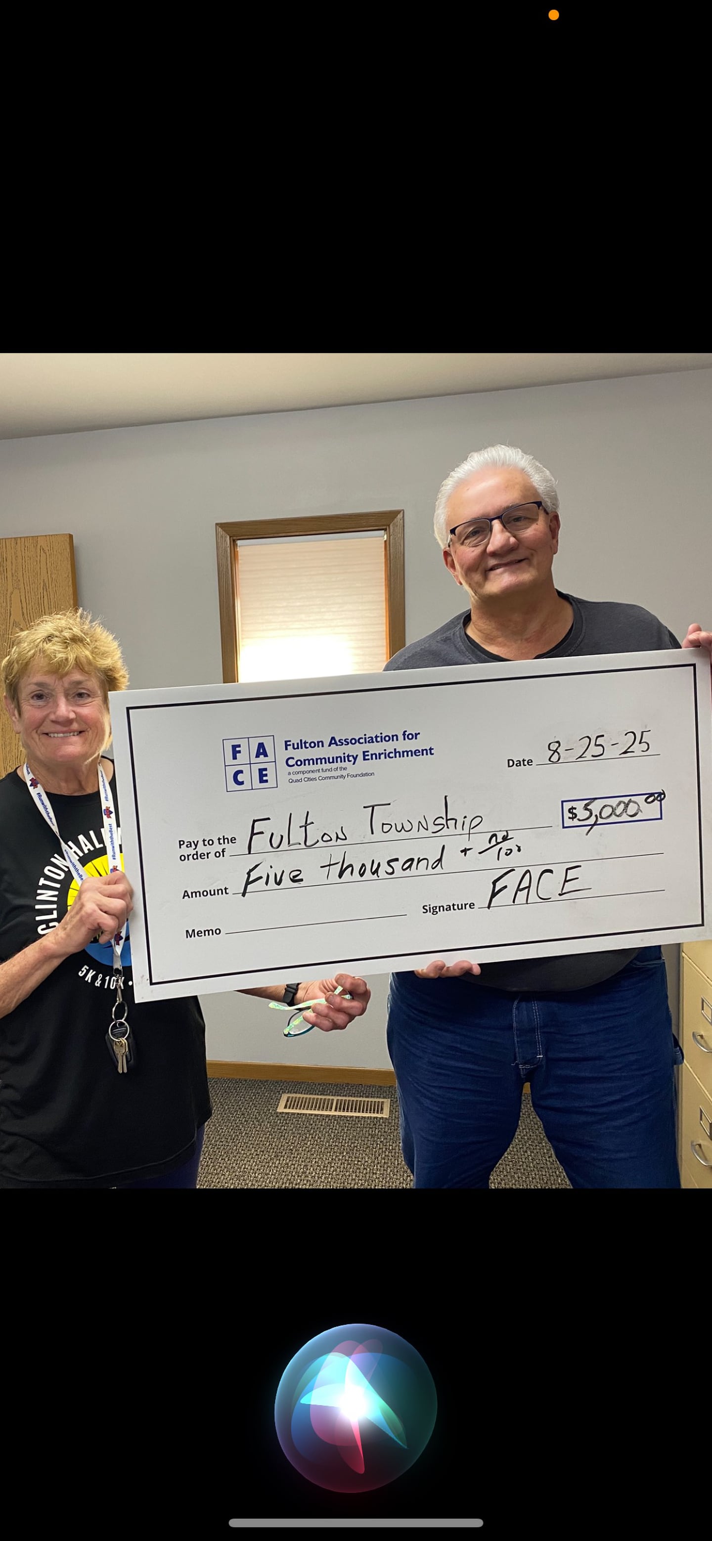Fulton Township Supervisor Dave Jindrich receives a grant for $5,000 from FACE Board member Jean Roeder.