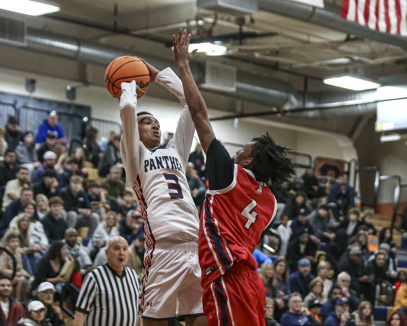 Oswego's Ethan Vahl (3) shoots while being defended by West Aurora's Antonio Higgins (4) during their basketball game between West Aurora at Oswego Monday, Nov 24, 2025 in Oswego.