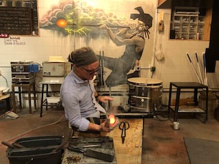Brian Dunlavy at The Glass Smith in downtown Richmond uses wet newsprint to shape hot glass on Thursday, March 14, 2024.