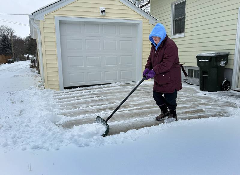 Marilyn Kollie clears snow from her driveway on East Sixth Street in Sterling on Wednesday, Feb. 12, 2025. Several inches of light, fluffy snow fell across the region.