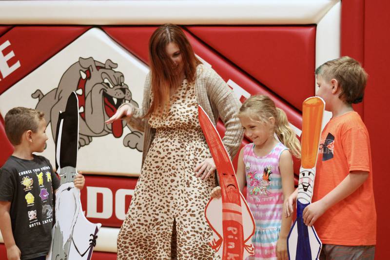 Children's author Amanda Fox helps East Coloma Nelson School students take on the role of markers from her book "Markertown" on Friday. From left, Caleb Metzger, Annabelle Palumbo and Jacek Anderson.