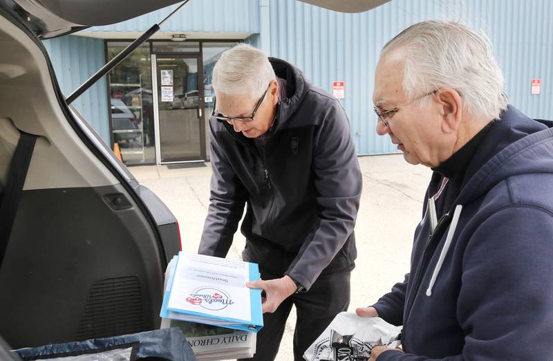 Volunteers Tom Webber (left) and Robert Walters load up their van with a Meals on Wheels delivery Tuesday, April 23, 2024, at the Voluntary Action Center in Sycamore.