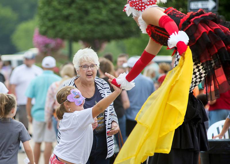 Skylynn Lance, 7, of Polo high fives a street performer Saturday, August 14, 2022 during Dixon Main Street’s Venetian Night. Lance and great-grandma Mirim Blackburn were both enjoying the sights and sounds of the evening.