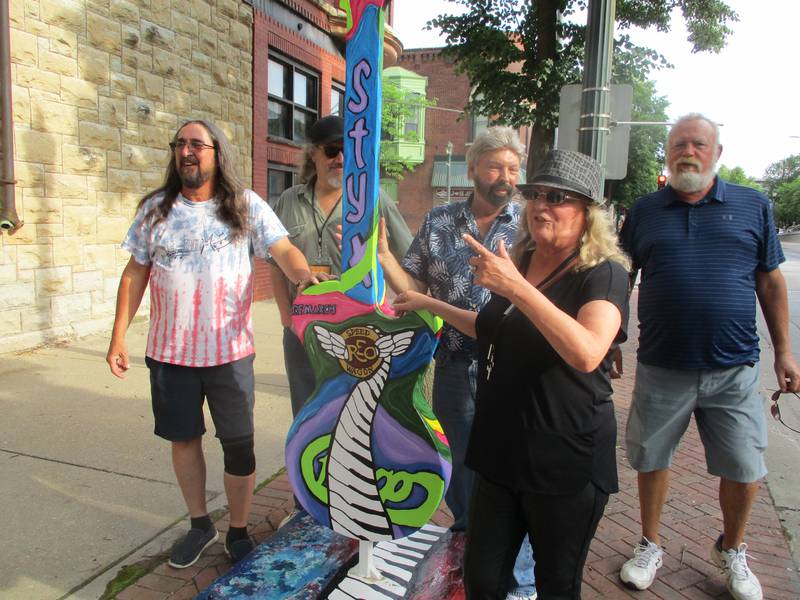 Margaret "Margie" Keniley of Shorewood on Thursday poses with friends by the guitar she painted and calls "GOATILL," which stands for Greatest of All-Time Illinois. The guitar located outside the Old National Bank on Chicago Street is part of the "Ready to Rock" street art project in downtown Joliet. June 1, 2023.