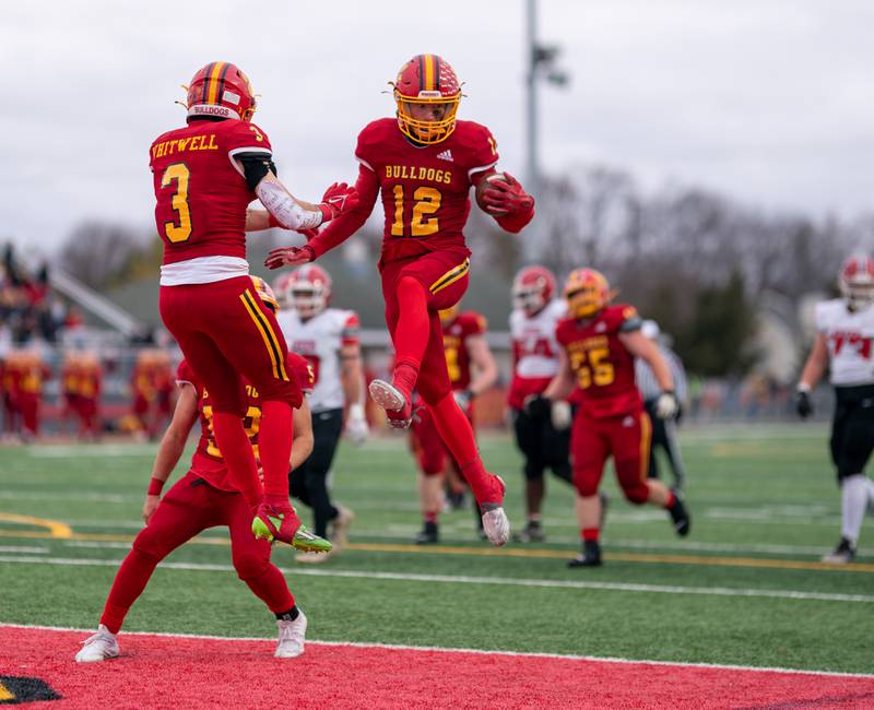 Batavia’s Luke Alwin (12) celebrates with Ryan Whitwell (3) after scoring a touchdown against Yorkville during a 7A quarterfinal playoff football game at Batavia High School on Saturday, Nov 12, 2022.