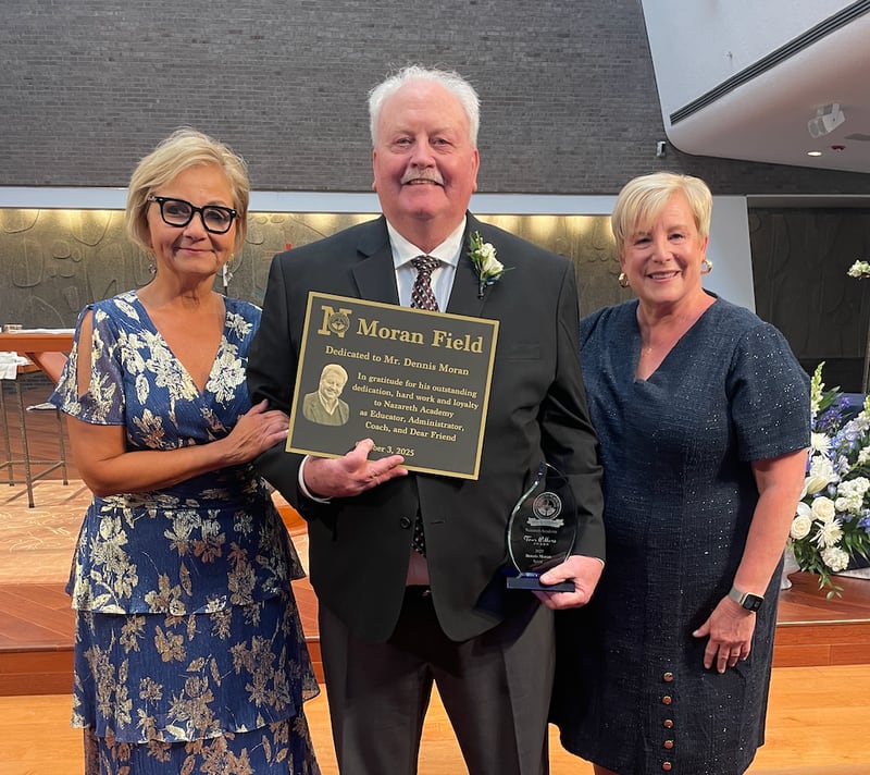 Nazareth Academy President Deborah Tracy (left) and principal Therese Hawkins present Dennis Moran with a plaque dedicating the school's football field in Moran's honor