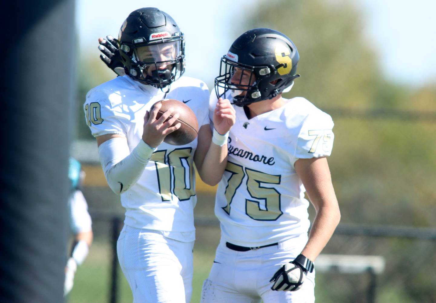 Sycamore’s Burke Gautcher, left, is greeted in the end zone by Owen DePauw after a Gautcher touchdown against Woodstock North in varsity football in Woodstock Saturday.