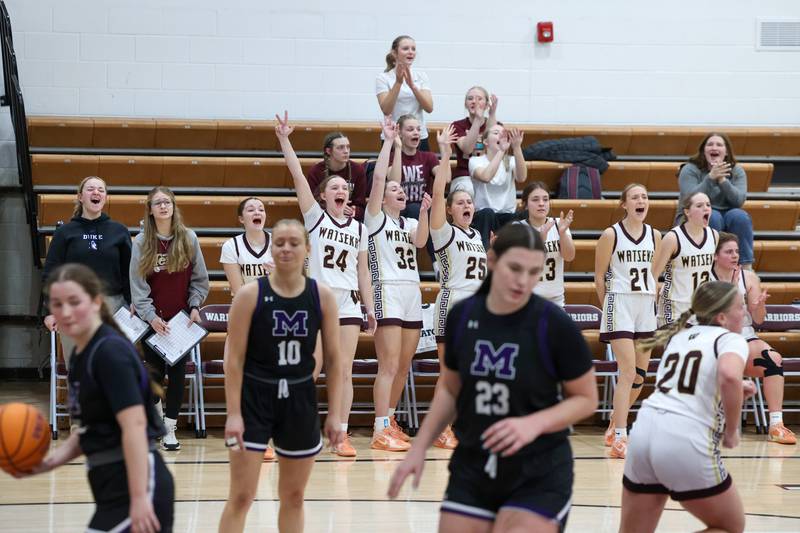Watseka/Milford players celebrate a 3-pointer by teammate Rennah Barrett to bring the Warriors within two points of Manteno at half time during the Warriors' 57-52 loss to Manteno on Wednesday, Jan. 21, 2026.