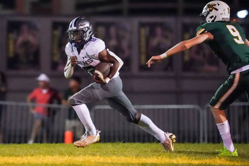 Oswego East's Jasiah Watson (13) carries the ball against Waubonsie Valley during a football game at Waubonsie Valley High School in Aurora on Friday, Aug. 25, 2023.