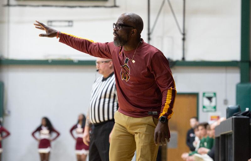 Christ the King head coach Troy Caldwell talks with his team on the floor during Friday night's game at Bishop McNamara.
