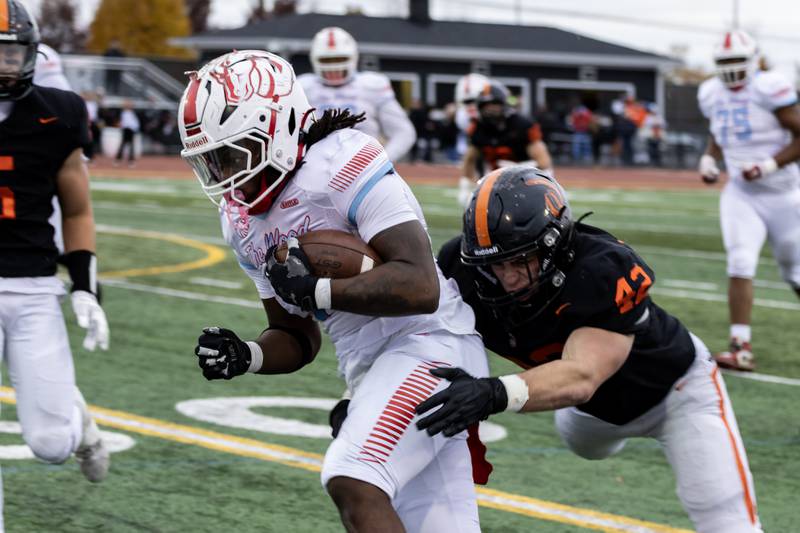 Lincoln-Way West's Gavin Larson attempts to tackle Kenwood's Jayvon Anderson during a 7A varsity football playoff game at Lincoln-Way West on Nov. 8, 2025.