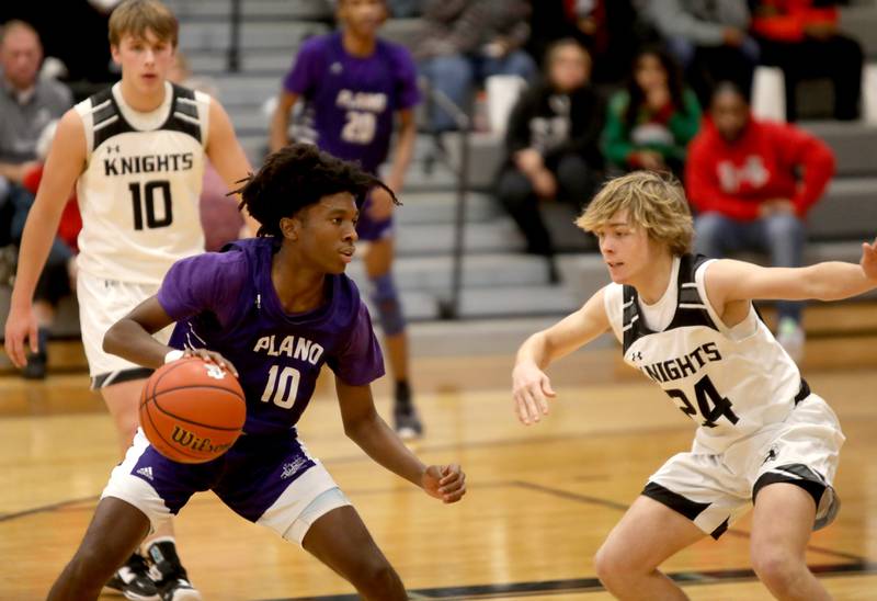 Kaneland’s Davione Stamps (left) looks for an opening past Kaneland’s Luke Reinert during a game at Kaneland in Maple Park on Tuesday, Dec. 20, 2022.