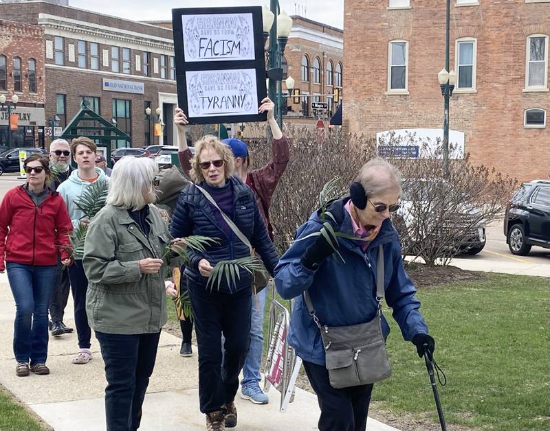 Participants hold signs during a procession at a Palm Sunday Faith Action event on Sunday, March 29, 2026, in front of the DeKalb County Courthouse in Sycamore. Area Christian ministers organized the event to combat the rise of Christian nationalism in the U.S.