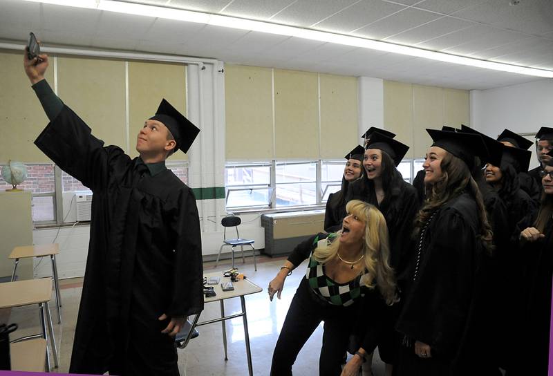 Advisor Teresa Eick-George photo bombs Tyler Cunningham as he takes a selfie with his classmates Sunday, May 22, 2022, before the Alden-Hebron High School commencement ceremony in Hebron.