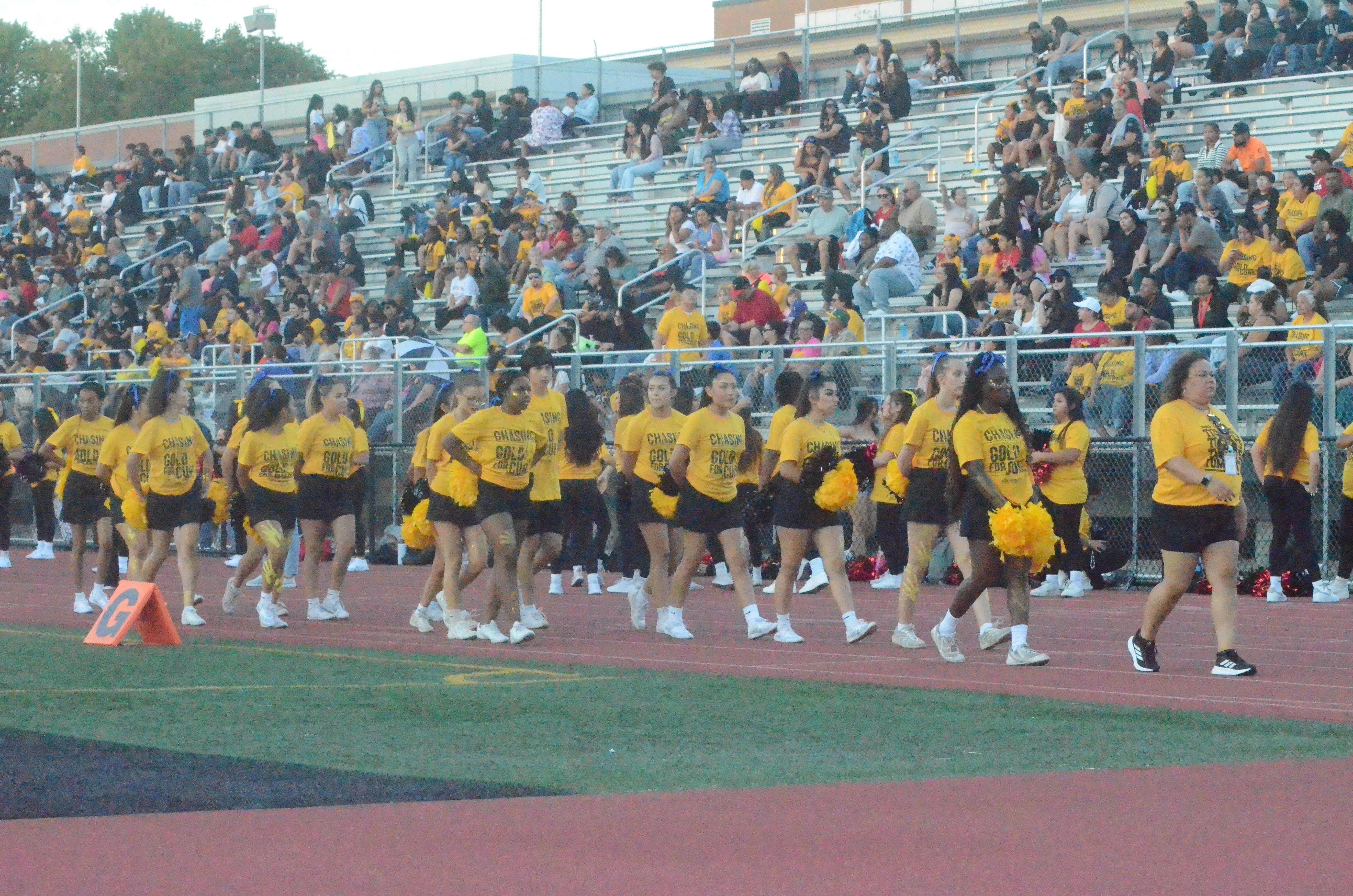 East Aurora High cheerleaders wear gold-colored T-shirts at a football game against Streamwood on Friday, Sept. 12, 2025, to support Cal's Angels, a St. Charles-based nonprofit foundation dedicated to granting wishes, raising pediatric cancer awareness and funding research.