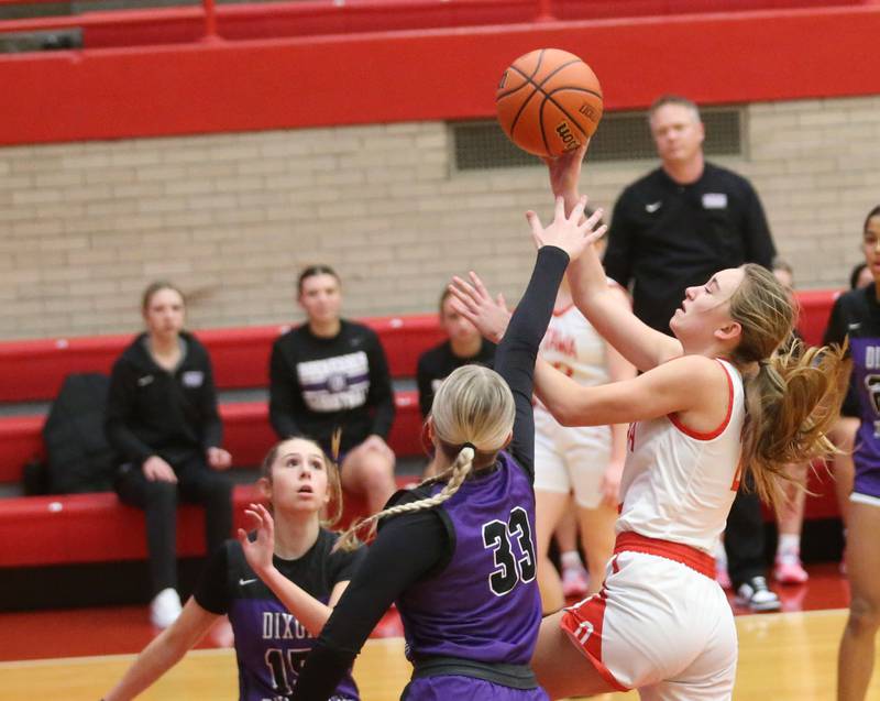 Ottawa's Ashlynn Ganiere runs into the lane to score a basket over Dixon's Jessie Pitman on Wednesday, Nov. 29, 2023 at Kingman Gym.